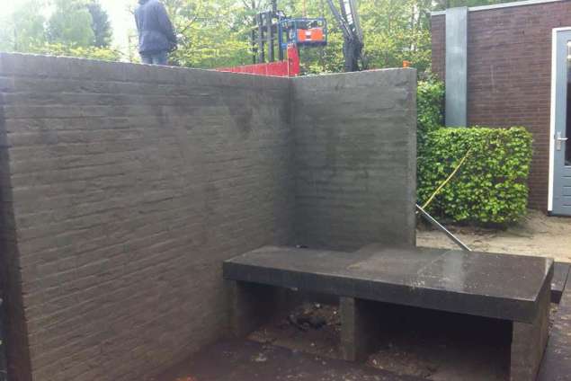cementeren van een tuinmuur en het leggen van een betonplaat voor een leuk knus zitje